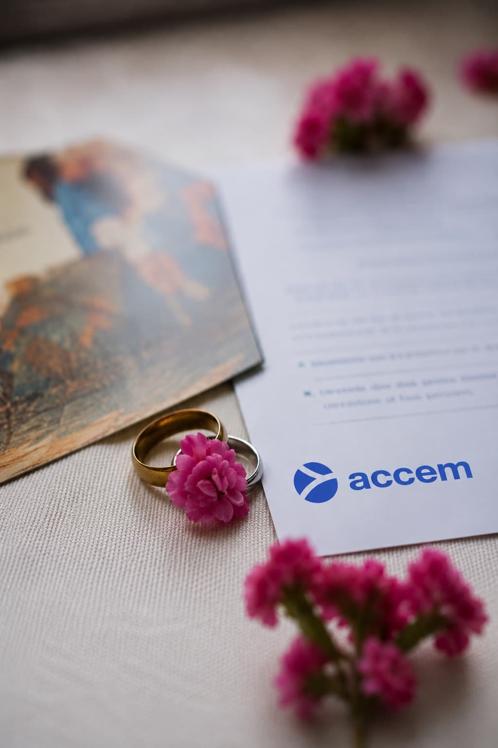 Detalle de tarjetas solidarias de boda Accem con alianzas y flores